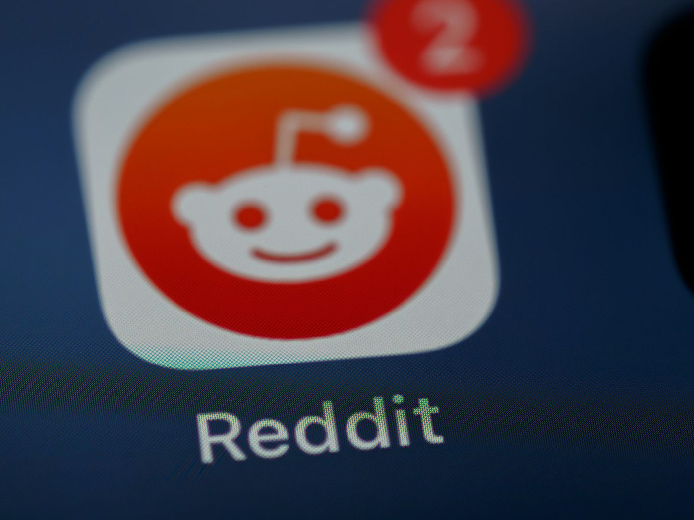 Close-up of the Reddit app icon with a notification badge on a phone screen